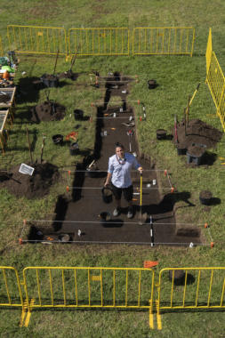 Tlingit and Unangax̂ visual artist Yéil Ya-Tseen Nicholas Galanin stands inside his artwork, an outline of a grave dug for a statue