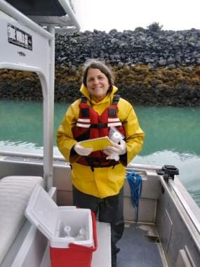 A woman standing on the deck of a boat