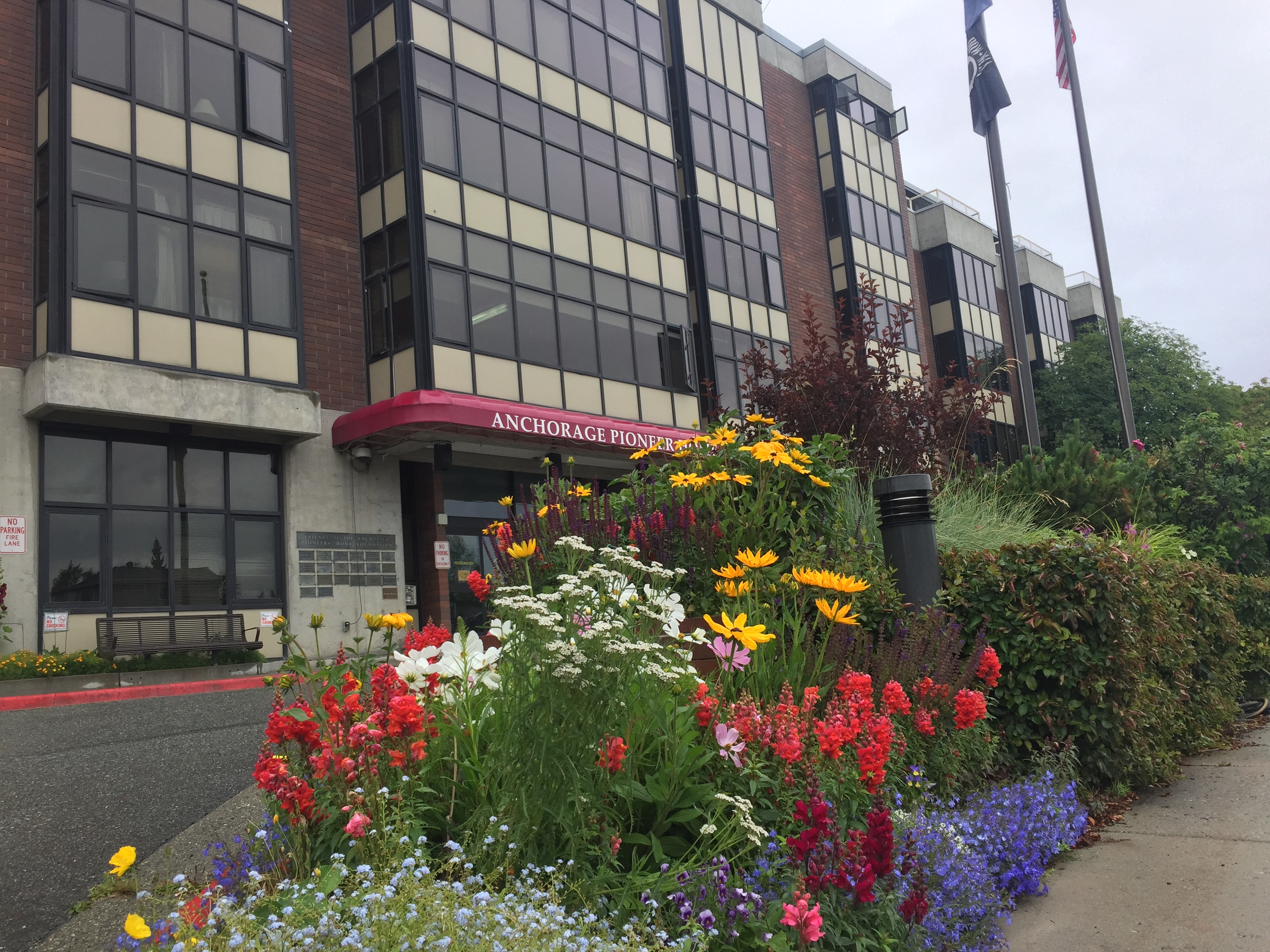The front entrance to the Anchorage Pioneer Home with flower beds