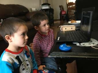 Siblings Timothy Ackerman, left, and James Ackerman, ages 5 and 4, follow classes at home via distance learning in the spring of 2020.