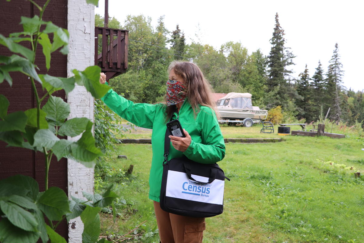 A census worker knocks on a door in Dillingham