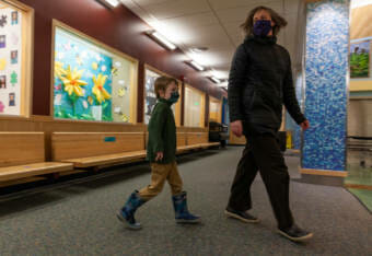 Maxwell Framke, 6, follows Sayéik Gastineau Community School kindergarten teacher Diana Brann on his first day of school on Thursday, Jan. 14, 2021, in Juneau, Alaska. (Photo by Rashah McChesney/KTOO)