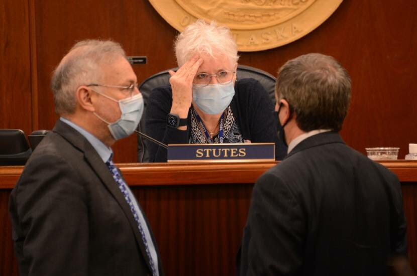 Alaska Speaker of the House Louise Stutes, R-Kodiak, presses a hand to her forehead as she talks to Rep. Bryce Edgmon, I-Dillingham (left) and House Majority Leader Chris Tuck, D-Anchorage on Wednesday, March 3, 2021 in the Alaska State Capitol at Juneau, Alaska. (James Brooks/Anchorage Daily News via AP, Pool)