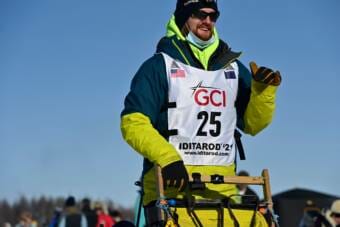 A man on the runners of a dogsled
