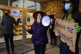 Louise Brady speaks to a crowd of protestors outside of the ADF&G office in Sitka. Brady is a member of the Sitka Tribe of Alaska Tribal Council, but she was speaking as an individual at the event. (KCAW/Berett Wilber)