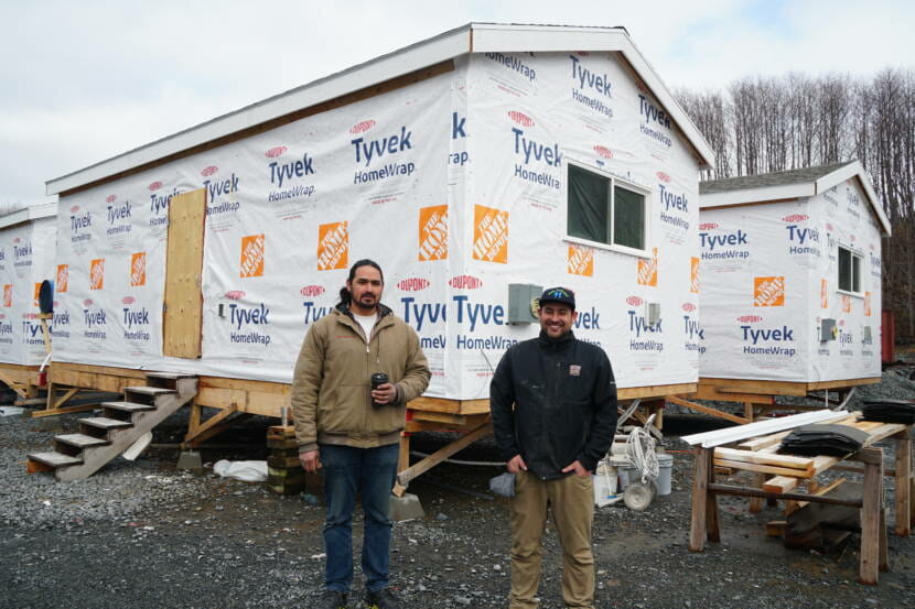Co-owners of Sitka Construction Solutions, Derek James and Kris Karsunky, stand in front of the four 450-square foot houses that they’re constructing for the Yakutat Tlingit Tribe. The company does standard construction projects like heat pump installs and single family homes, but lately, they’ve been focusing more on the “mini home” concept. “We could do these for the rest of our career if we wanted to,” James said. “We saw what we were expecting with the demand, and now we just have to get a process out there.” (Photo by Erin McKinstry/KCAW)