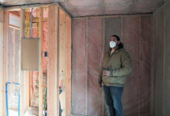 Co-owner of Sitka Construction Solutions, Derek James, points out the future bathroom in an unfinished “mini home.” (KCAW/Erin McKinstry)
