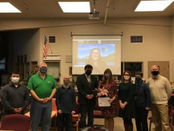 Juneau School District Superintendent Bridget Weiss poses with school board members during a meeting on Tuesday, Sept. 14, 2021. Lisa Parady with the Alaska Superintendents Association showed up via Zoom to present Weiss with an award.