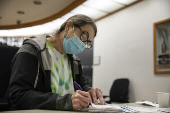 Tami Burgett signs off on a set of ballots as the Canvass Review Board works to certify the local election on Tuesday, Oct. 19, 2021, in Juneau, Alaska. (Photo by Rashah McChesney/KTOO)