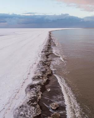 An aerial photo looking down along the Arctic Ocean coastline