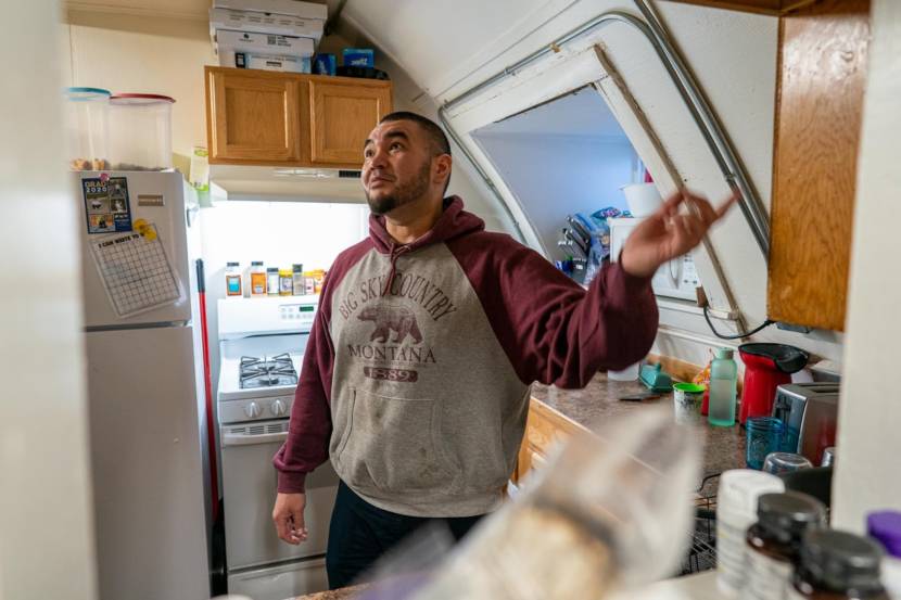 A man wearing a Big Sky Montana hoodie standing in a crowded kitchen with a sloping ceiling