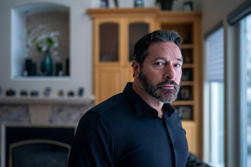 A man standing at a window inside a house