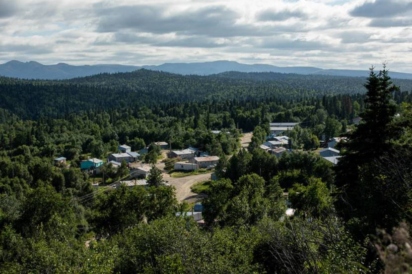 A view from above of a houses in Russian Mission, clustered together amid forest.