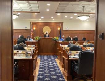 Alaska House Speaker Louise Stutes (R-Kodiak), center, listens as Rep. Cathy TIlton (R-Wasilla), right with back to camera, speaks in the House chamber in the Alaska State Capitol in Juneau on the first day of the session, Jan. 18, 2022. (Photo by Andrew Kitchenman/KTOO and Alaska Public Media)