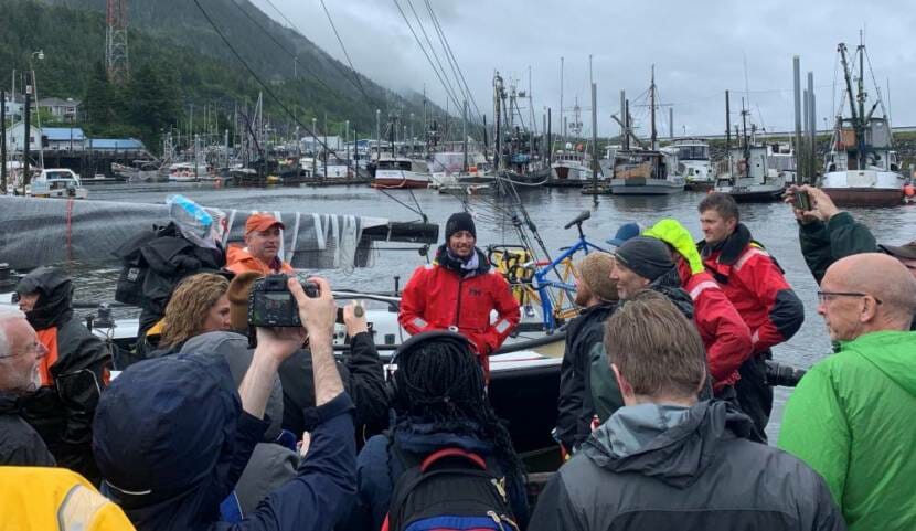 A group of people in rain gear standing by a harbor