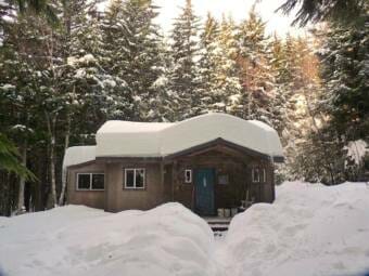 A small hose with about two feet of snow on its roof