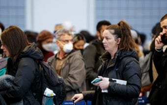 A crowd of worried-looking people in an airport.