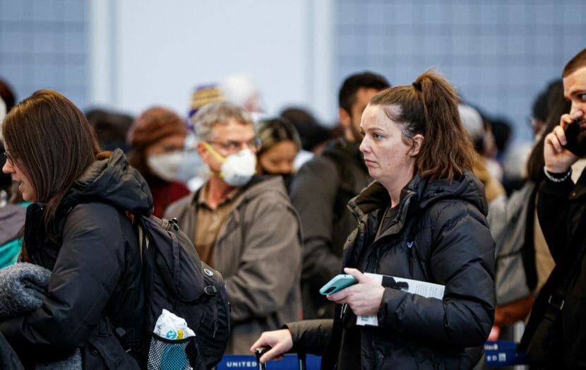 A crowd of worried-looking people in an airport.