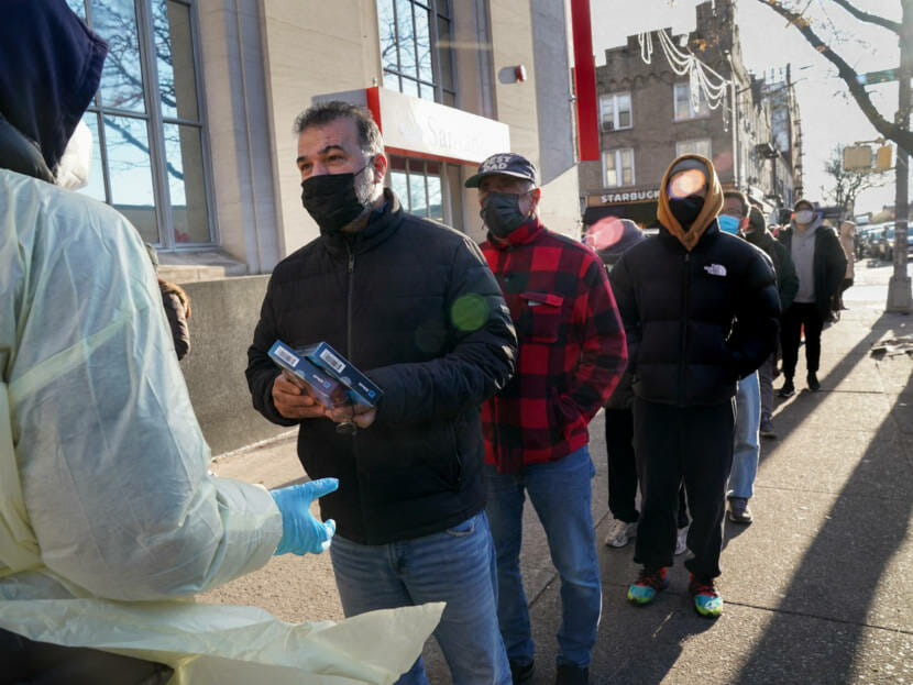 A line of people on a New York sidewalk waiting to pick up COVID rapid tests