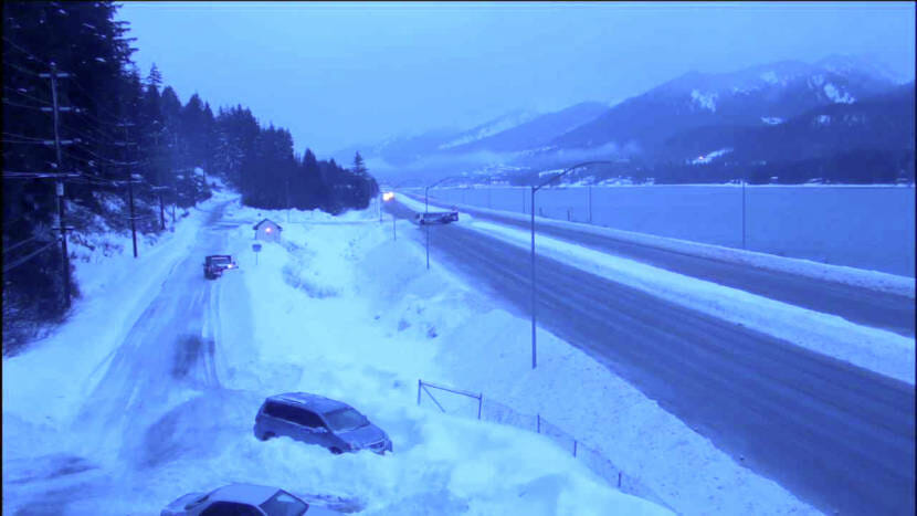 Two cars in deep snowbanks along a snowy road