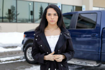 A portrait of a teenaged girl standing in a parking lot