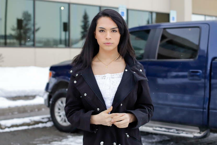 A portrait of a teenaged girl standing in a parking lot