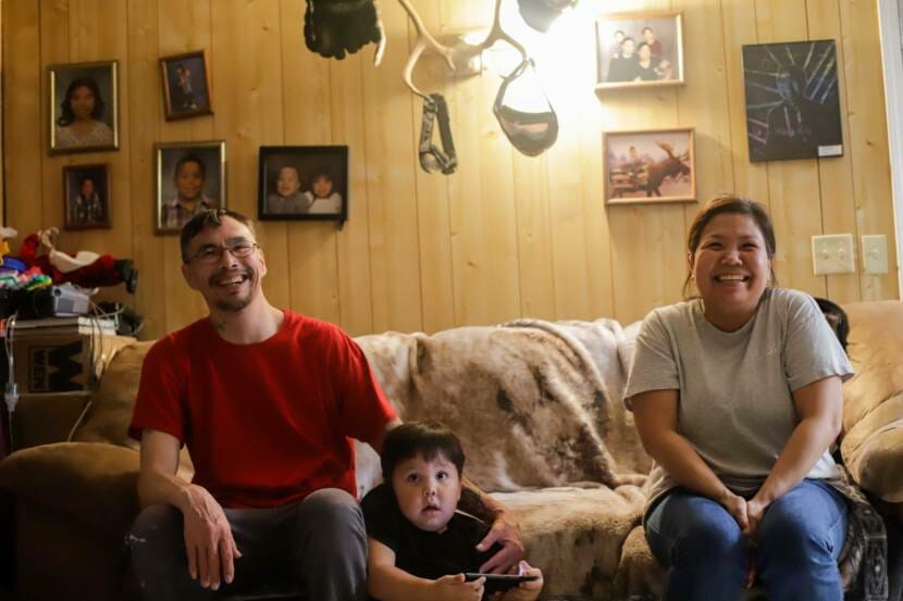 A couple and child sitting on a couch