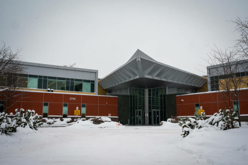The front of a red building, with snow coming down