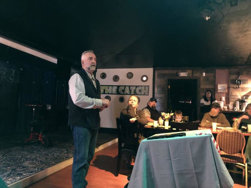 A man speaks to an audience from a stage