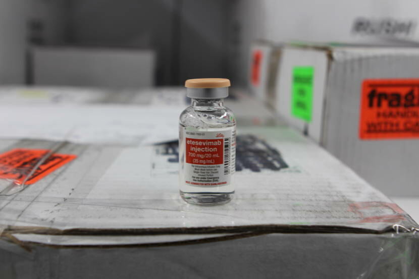 A vial of clear liquid sitting on top of a cardboard box