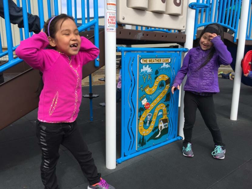 Two young girls playing on a playground