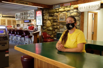 A woman standing behind a bar