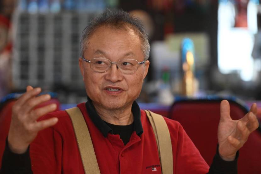 A man in suspenders, gesturing