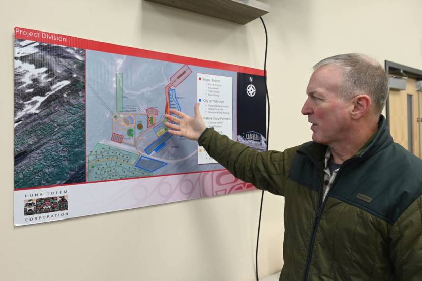 A middle-aged man points at a map