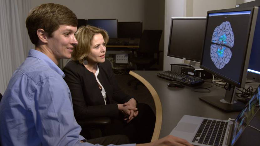 A man and a woman looking at a computer screen