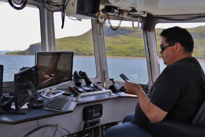 A man in the cabin of a fishing boat