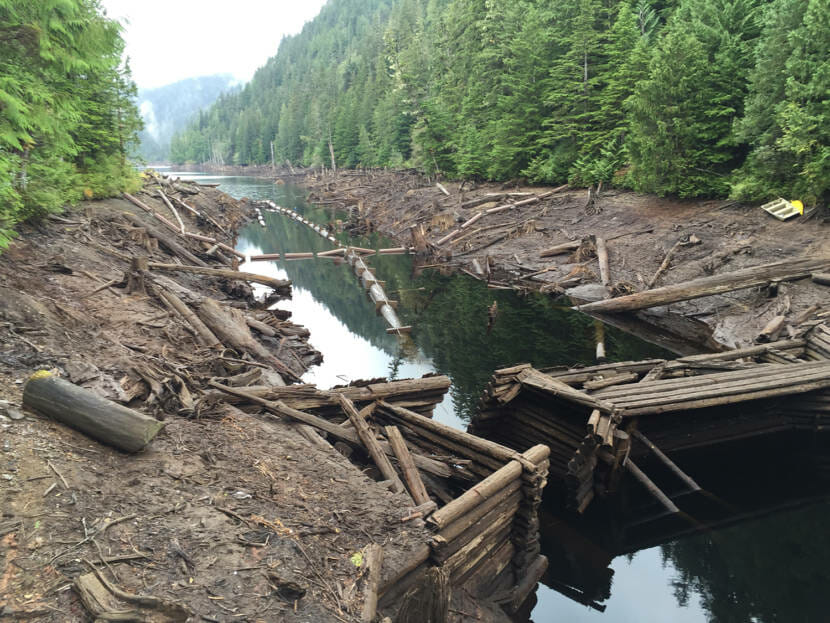 Muddy waterlines and reservoir infrastructure exposed by low water levels in a reservoir.