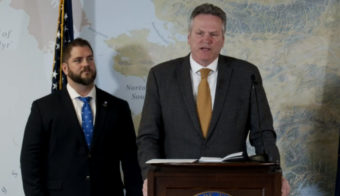 Adam Crum, commissioner of the Alaska Department of Health and Social Services, listens as Gov. Mike Dunleavy talks about the division of the agency into two smaller departments on March 21, 2022, in the Atwood Building in Anchorage. The Department of Health and the Department of Family and Community Services will be reorganized on July 1, 2022. (Screen capture of Dunleavy livestream)