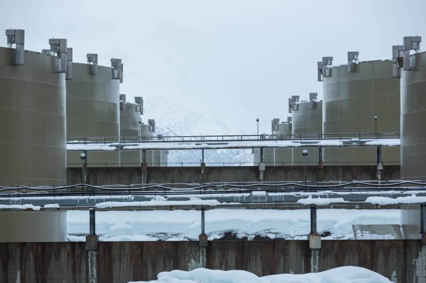 A photo from a perspective looking between two rows of large oil storage tanks