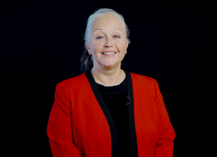 A formal portrait of a woman wearing a red blazer
