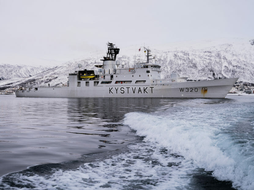 A Coast Guard cutter with snowy mountains in the background