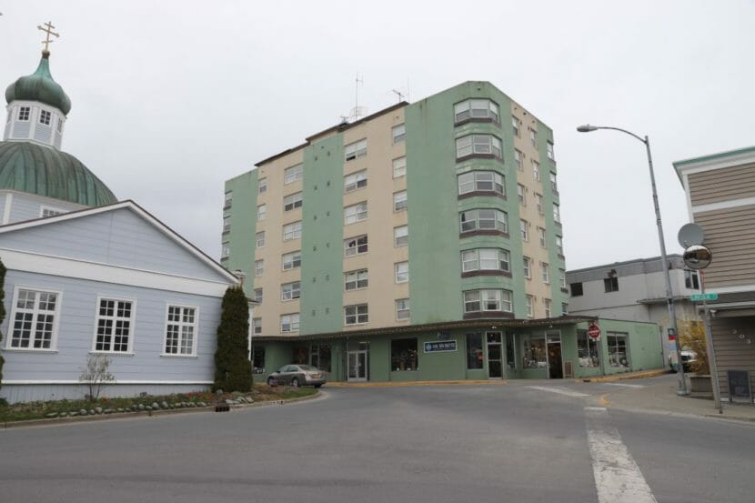 A 7-story apartment building next to a church