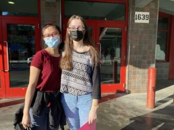 Students Jowielle Corpuz and Sydney Carter pose together in front of uneau Douglas High School Yadaa.at Kalé on April 4, 2022.