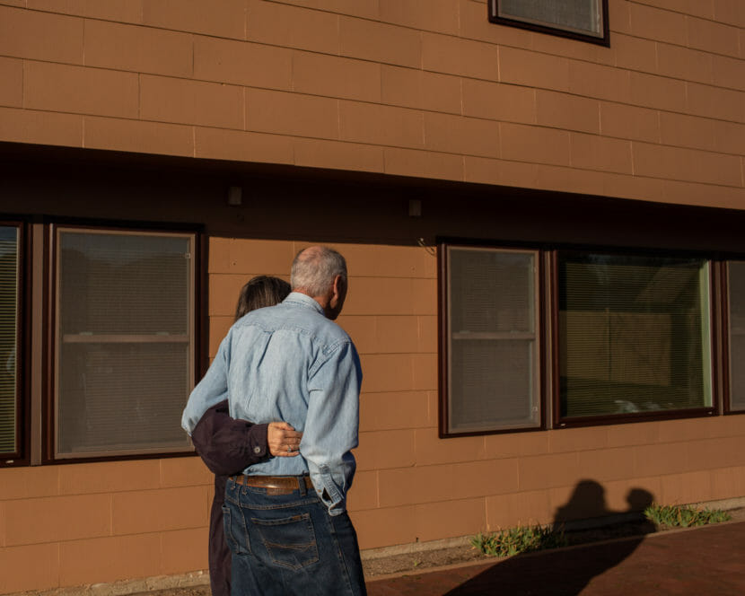A father and daughter walking with their arms around each other