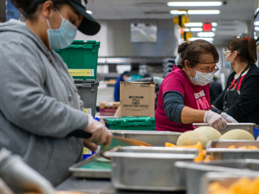 masked women cutting canteloupe
