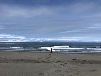 A surfer walks toward the water