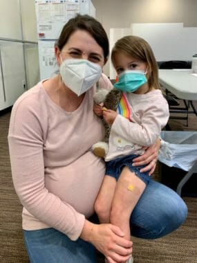 A woman holes a child on her knee