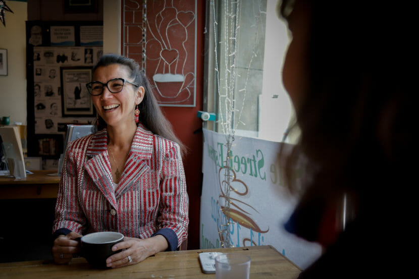A woman sitting at a cafe table by a window