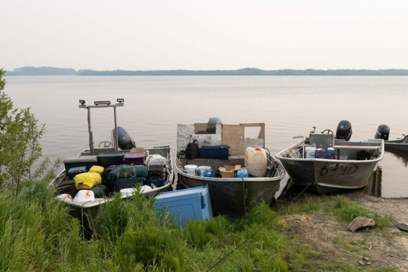 Three skiffs on a river bank, loaded with supplies