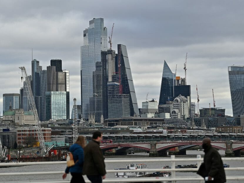 People walking across a bridge with skyscrapers in the background